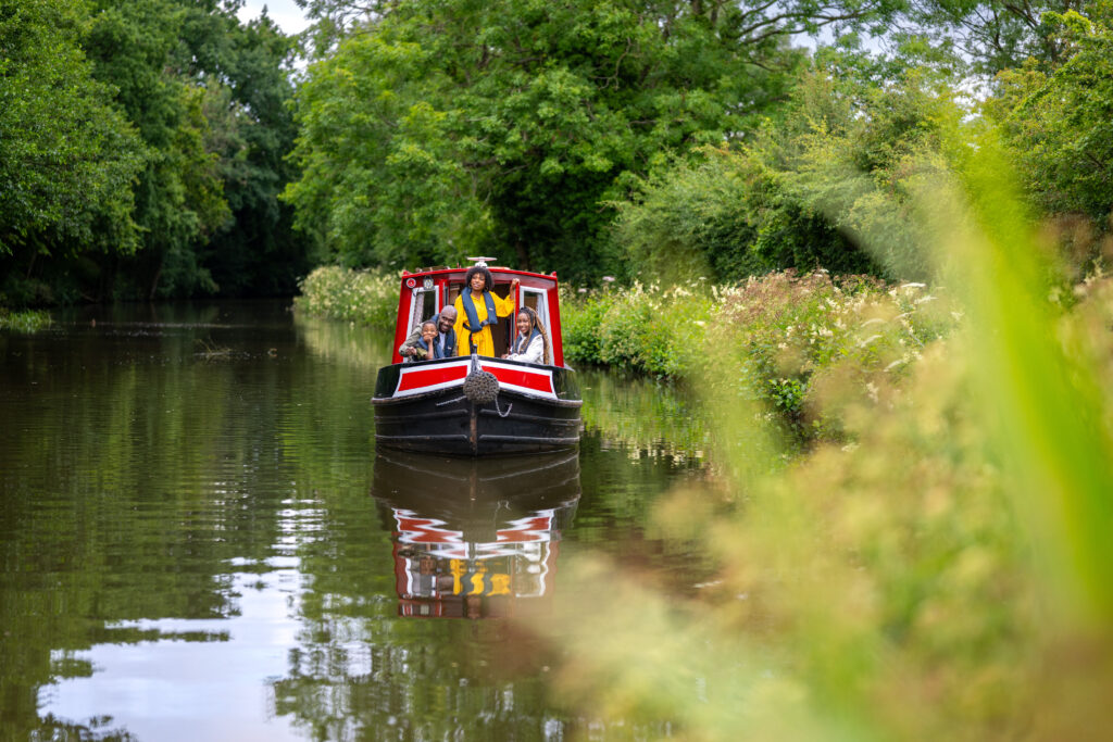 A family of 4 on a narrowboat during the summer