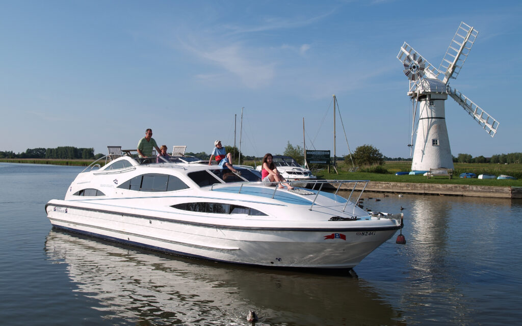 Boat hire on the Norfolk Broads - A Luxury Broads Cruiser passing Thurne